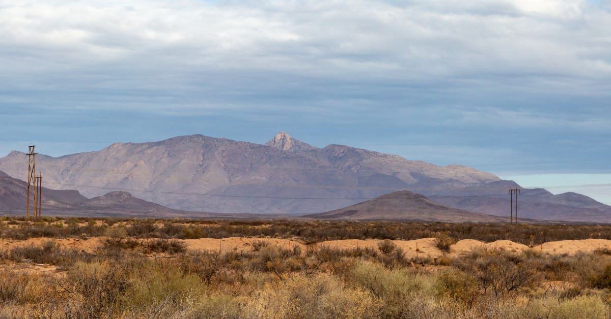 View of desert and mountains with energy electric or phone lines.